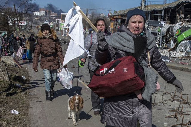 A woman holds a white cloth on a stick in Ukrainian city of Irpin on March 10,2022 as people flee the cities of Irpin and Bucha from Russian forces. (Photo by Heidi Levine for The Washington Post)