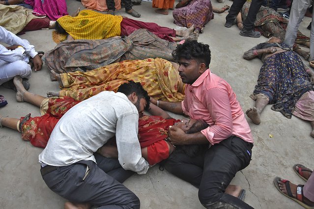 People mourn next to the bodies of their relatives outside the Sikandrarao hospital in Hathras district about 350 kilometers (217 miles) southwest of Lucknow, India, Tuesday, July 2, 2024. A stampede among thousands of people at a religious gathering in northern India killed at least 60 and left scores injured, officials said Tuesday, adding that many women and children were among the dead and the toll could rise. (Photo by AP Photo)