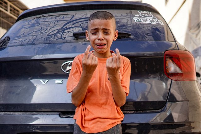 A boy reacts as he mourns the loss of his child sister who was killed in the aftermath of overnight Israeli bombardment in al-Maghazi in the central Gaza Strip, outside the morgue of the Aqsa Martyrs hospital in Deir el-Balah on June 25, 2024 amid the ongoing conflict in the Palestinian territory between Israel and Hamas. (Photo by Bashar Taleb/AFP Photo)