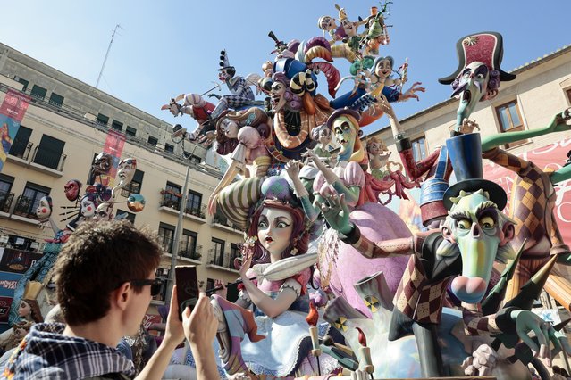 A man takes a photo of one of the falla sculptures in Valencia, Spain, 16 March 2023. The Fallas festival is a fortnight-long fiesta in which installations of parodic papier-mache, cardboard, and wooden sculptures are traditionally burnt every year on the last day of the event, usually on 19 March, in the so-called “Crema” to end the festivities. (Photo by Ana Escobar/EPA/EFE)