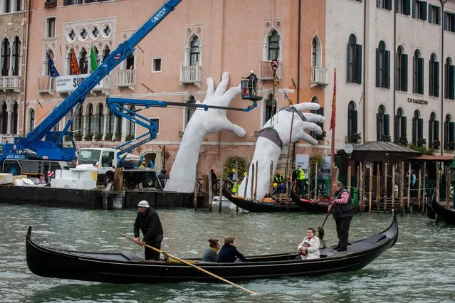 Workers finish to prepare the exhibition “SUPPORT” by Lorenzo Quinn, during the 57th Biennale Arte on May 11, 2017 in Venice, Italy. The 57th International Art Exhibition of La Biennale di Venezia will be open to the public from the June 13 to November 26, 2017. (Photo by David Levene/The Guardian)