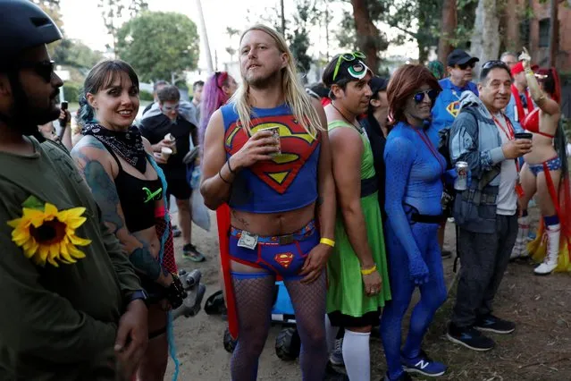 The Hash House Harriers running club assemble wearing superhero costumes before embarking on their Oscars weekend bar crawl along Hollywood Boulevard in Los Angeles, California, U.S., March 26, 2022. (Photo by Chris Helgren/Reuters)