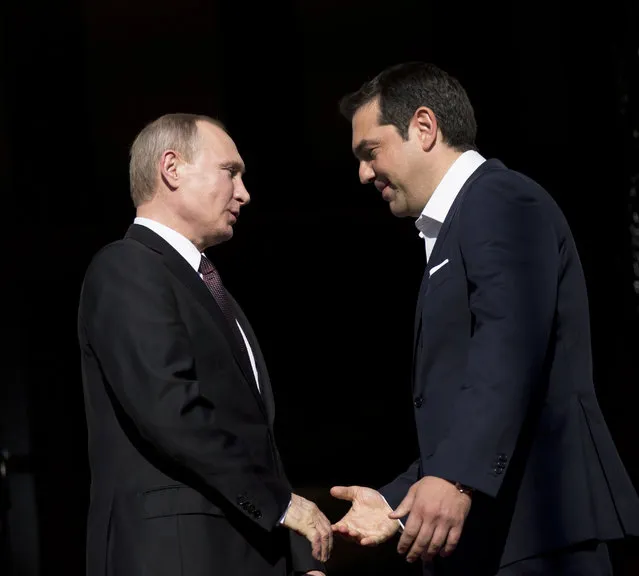 Greek Prime Minister Alexis Tsipras , right, shakes hands with Russian President Vladimir Putin before their meeting in Athens, Friday, May 27, 2016. (Photo by Petros Giannakouris/AP Photo)