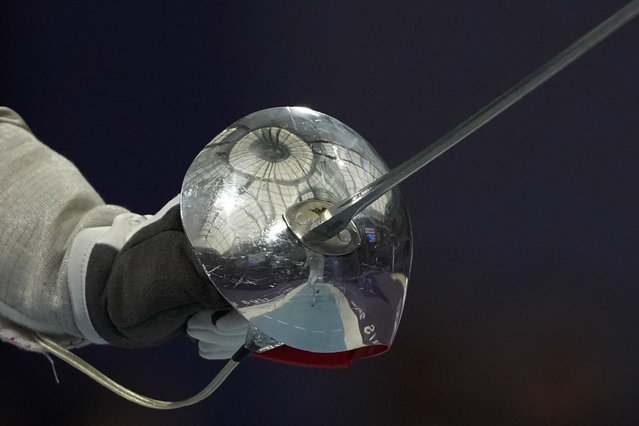 Grand Palais roof is reflected in a Bulgaria's Yoana Ilieva's sabre as she competes with Japan's Risa Takashima in the women's individual Sabre round of 32 competition during the 2024 Summer Olympics at the Grand Palais, Monday, July 29, 2024, in Paris, France. (Photo by Andrew Medichini/AP Photo)