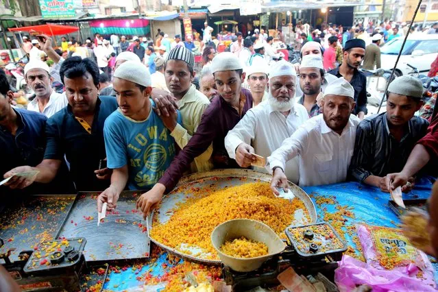Indian Muslims buy eatables to break the fast on the first day of the fasting month of Ramadan in Bhopal, India, 07 June 2016. Muslims around the world celebrate the holy month of Ramadan by praying during the night time and abstaining from eating and drinking during the period between sunrise and sunset. Ramadan is the ninth month in the Islamic calendar and it is believed that the Koran's first verse was revealed during its last 10 nights. (Photo by Sanjeev Gupta/EPA)
