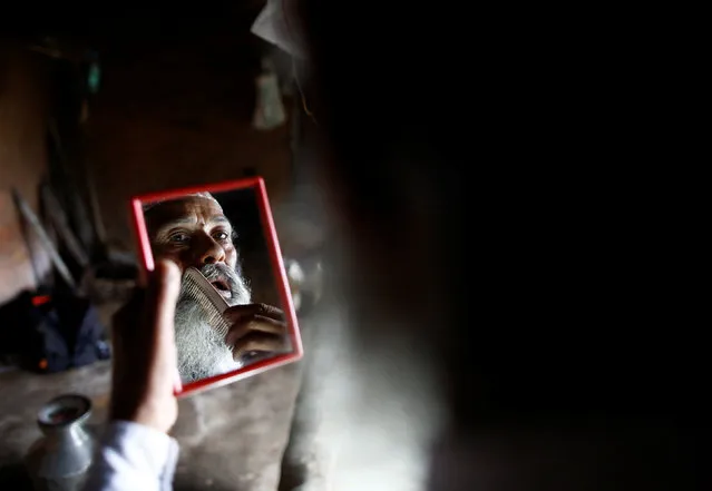 Durga Kami, 68, who is currently studying tenth grade at Shree Kala Bhairab Higher Secondary School, looks into a mirror as he combs his beard while getting ready for school in Syangja, Nepal, June 5, 2016. (Photo by Navesh Chitrakar/Reuters)