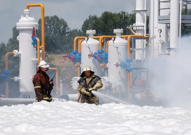 Ukrainian firemen use foam to extinguish a mock fire during an emergency training at an underground gas storage facility near Poltava, Ukraine, 15 July 2016. (Photo by Roman Pilipey/EPA)