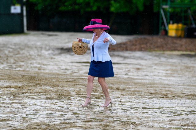 A woman walks through the mud to get to the grandstand ahead of the Preakness Stakes horse race at Pimlico Race Course, Saturday, May 18, 2024, in Baltimore. (Photo by Nick Wass/AP Photo)
