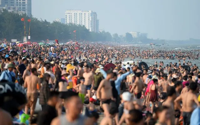 This picture taken on July 20, 2019 shows people relaxing on Sam Son beach in Thanh Hoa province. There are few beaches in northern Vietnam, and Sam Son in Thanh Hoa province has long been a popular destination for Vietnamese daytrippers. But its beauty has proven both a blessing and a curse, leading vacationers to pack out the 16 kilometer-long (9.9 mile-long) beach. (Photo by Nhac Nguyen/AFP)