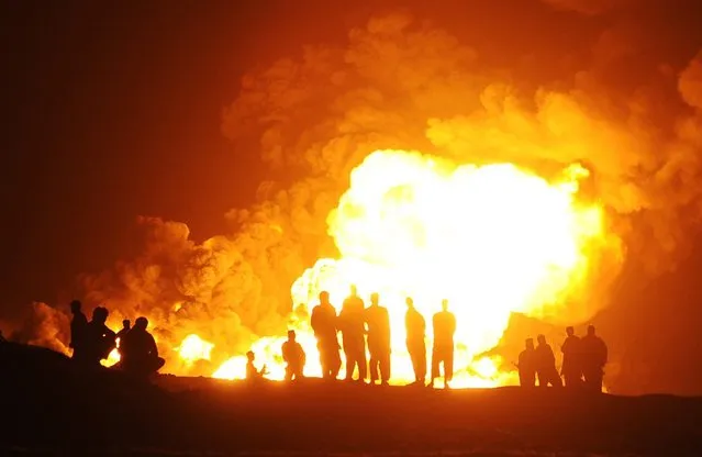 Flames rise from oil tanker trucks after an attack by Taliban militants on the outskirts of Kabul, Afghanistan, 05 July 2014. Dozens of tanker trucks carrying oil were hit by rockets fired by suspected Taliban militants. (Photo by Jawad Jalali/EPA)