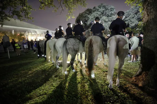 Police on horseback begin to move in and push protesters from Pioneer Park following a rally against white supremacists at City Hall in Dallas, US on August 19, 2017. (Photo by Tom Fox/AP Photo/The Dallas Morning News)