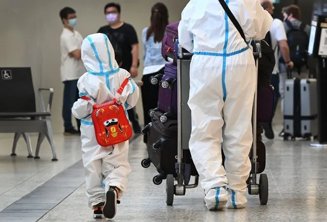International travellers wearing personal protective equipment (PPE) arrive at Melbourne's Tullamarine Airport on November 29, 2021 as Australia records it's first cases of the Omicron variant of Covid-19. (Photo by William West/AFP Photo)