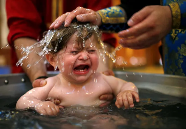 A baby is baptised during a mass baptism ceremony at the Holy Trinity Cathedral in Tbilisi, Georgia July 13, 2016. (Photo by David Mdzinarishvili/Reuters)