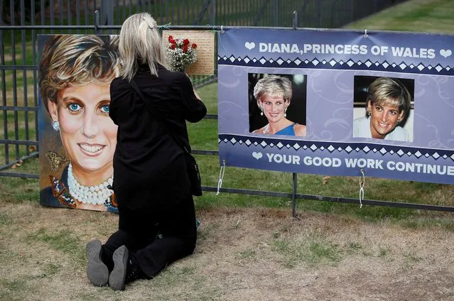 A person places flowers in a tribute to Princess Diana, on the 25th anniversary of her death, outside Kensington Palace, in London, Britain on August 31, 2022. (Photo by Peter Nicholls/Reuters)