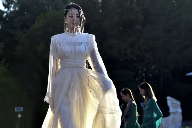 A model displays an outfit from the collection by Kyrgyzstan designer Nazira Talaibekova during the World Nomads Fashion festival Issyk-Kul 2022, at Cholpon-Ata, a resort town on the northern shore of Lake Issyk-Kul, 207 kilometers (129 miles) east of Bishkek, Kyrgyzstan, Thursday, July 21, 2022. On the shore of one of the world's largest lakes, high up in Kyrgyzstan's Tian Shan mountains, models strutted and sashayed in outfits mixing the ancient and modern at the World Nomads Fashion festival. (Photo by Vladimir Voronin/AP Photo)