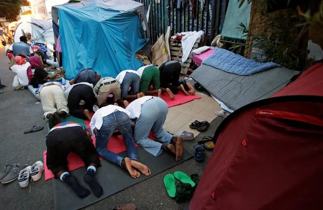 Migrants pray at a makeshift camp in Via Cupa (Gloomy Street) in downtown Rome, Italy, August 1, 2016. (Photo by Max Rossi/Reuters)