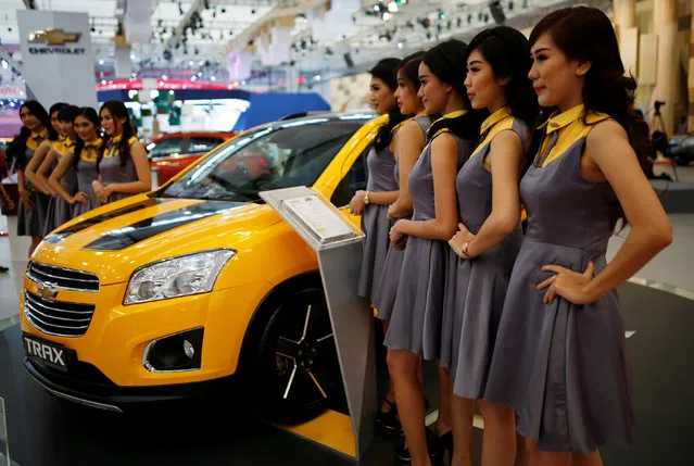 Models pose for photographs beside a Chevrolet Trax at the Indonesia International Auto Show in Tangerang, west of Jakarta, Indonesia August 11, 2016. (Photo by Darren Whiteside/Reuters)