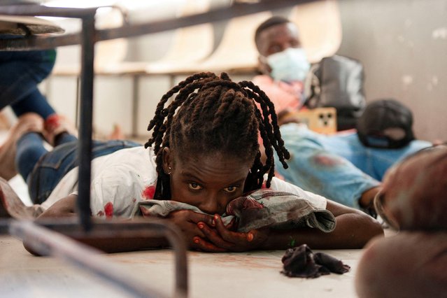 An injured woman looks on after armed men opened fire on a group of journalists who gathered for a government press conference set to announce the reopening of Haiti's largest public hospital, according to a witness who spoke to Reuters, in Port-au-Prince, Haiti, on December 24, 2024. (Photo by Fildor Pq Egeder/Reuters)