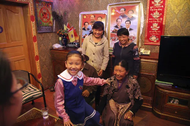 In this Thursday, September 17, 2015 photo, three generations of Tibetans pose for a photo at the home of grandparents Lhamu Tseren, seated at right, and her husband during a visit by local Communist Party cadres and journalists in Lhasa, the capital of the Tibet Autonomous Region in China. (Photo by Aritz Parra/AP Photo)