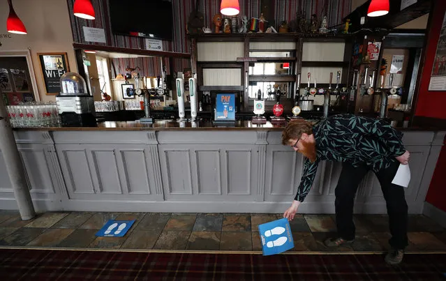 Owner Are Kjetil Kolltveit from Norway places markers for social distancing on the front of the bar at the Chandos Arms pub in London, Wednesday, July 1, 2020. Asking people in English pubs to keep their distance is going to be tough after they’ve had a few of their favorite tipples. Pub managers will have to be resourceful come Saturday, July 4, 2020, when they and other parts of the hospitality industry in England open their doors to customers for the first time since March 20, provided they meet COVID safety requirements. (Photo by Frank Augstein/AP Photo)