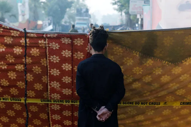 A boy looks at the cordoned crime scene after a shooting incident on a long march held by Pakistan's former Prime Minister Imran Khan, in Wazirabad, Pakistan on November 4, 2022. (Photo by Akhtar Soomro/Reuters)