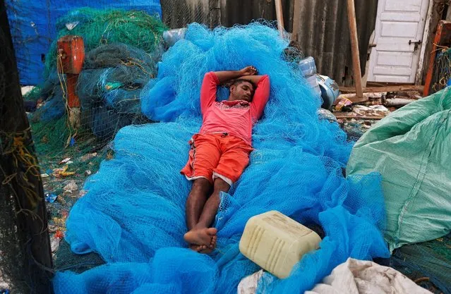 A man sleeps on fishing nets in Mumbai, India, August 23, 2016. (Photo by Shailesh Andrade/Reuters)