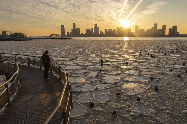 A person takes a photo of the Hudson River as it's covered by ice, Thursday, January 23, 2025, in New York. (Photo by Yuki Iwamura/AP Photo)