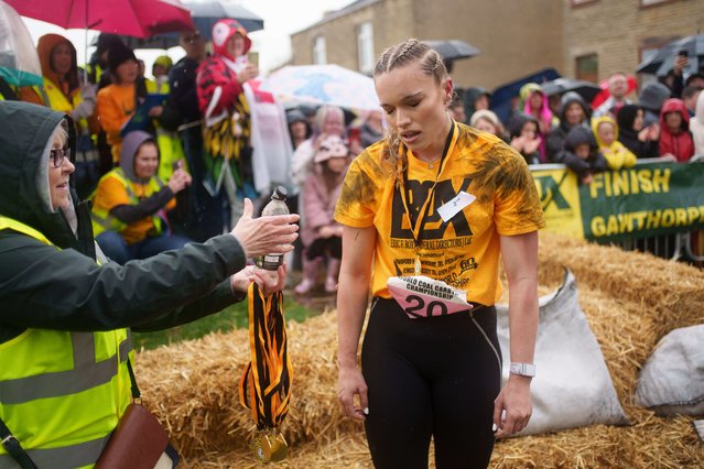 Jodie Ounsley who plays Fury in the British TV show Gladiators reacts after finishing the Women's Open Category race at the World Coal Carrying Championships in Ossett, West Yorkshire, England, Monday, April 21, 2025. (Photo by Jon Super/AP Photo)