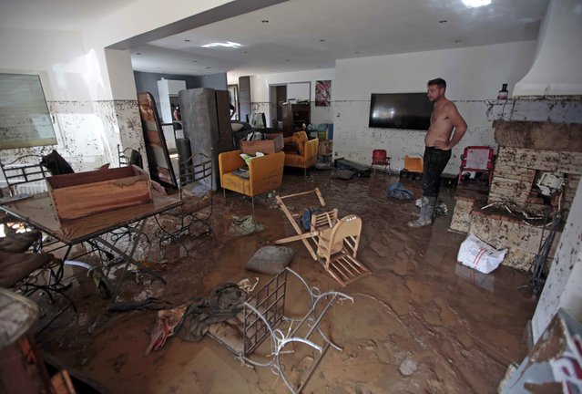 A man stands in the mud-covered living room inside his home following floods caused by torrential rain in Biot, France, October 4, 2015. (Photo by Eric Gaillard/Reuters)
