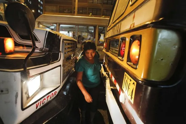 A woman squeezes between two public buses in downtown Lima, March 17, 2014. Bogota and two other Latin American capitals – Mexico City, and Lima in Peru – were named as the three capitals with the least safe transport systems for women in the Thomson Reuters Foundation poll of more than 6,550 women and gender and city planning experts. (Photo by Enrique Castro-Mendivil/Reuters)