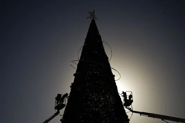 Municipal workers decorate a Christmas tree in Skanderberg Square in Tirana, Albania, Monday, December 5, 2022. (Photo by Andreea Alexandru/AP Photo)