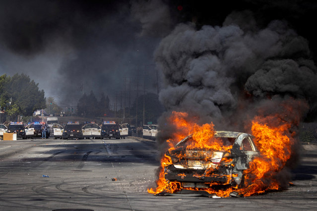 A car burns on Atlantic Boulevard during a standoff by protesters and law enforcement, following multiple detentions by Immigration and Customs Enforcement (ICE), in the Los Angeles County city of Paramount, California, U.S., June 7, 2025. (Photo by Barbara Davidson/Reuters)
