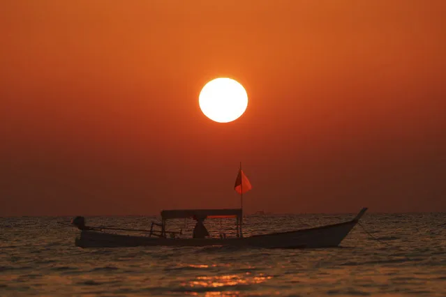 A boat standing on the seashore during sunset at Ngapali Beach, in Myanmar's western Rakhine State, on New Year's Eve, Saturday, December 31, 2022. (Photo by Aung Shine Oo/AP Photo)
