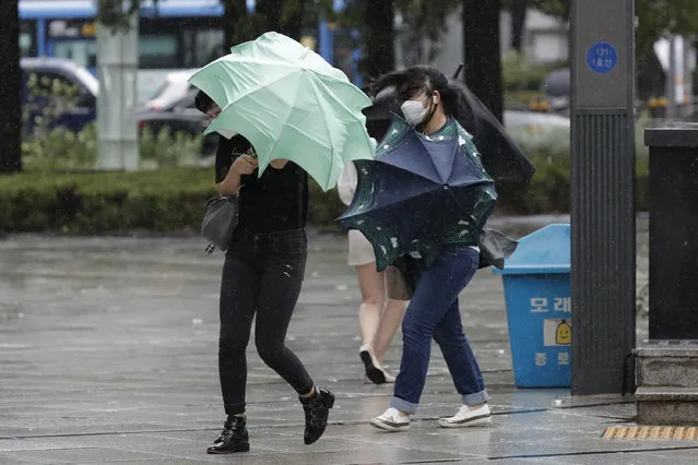 People struggle with their umbrellas against strong wind and rain in downtown Seoul, South Korea, Thursday, September 3, 2020. A powerful typhoon ripped through South Korea’s southern and eastern coasts with tree-snapping winds and flooding rains Thursday, knocking out power to thousands of homes. (Photo by Lee Jin-man/AP Photo)