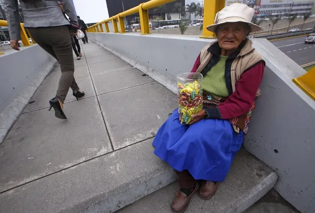 Street vendor Alejandra Baldani, 78, sells candies at a pedestrian bridge in San Borja district of Lima, October 22, 2015. Baldani earns ten soles ($3) a day from selling candies on the street. (Photo by Mariana Bazo/Reuters)