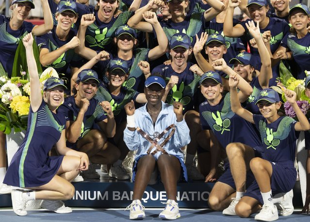 Victoria Mboko, center front, of Canada, poses with the ball crew following her win over Naomi Osaka, of Japan, in final action at the National Bank Open women's tennis tournament in Montreal, Thursday, August 7, 2025. (Photo by Christinne Muschi/The Canadian Press via AP Photo)