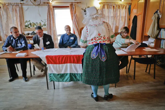 Edit Piros, an ethnic Hungarian from Romania, who moved to Hungary from Transylvania, central Romania, receives the ballot paper before voting in the referendum in the village of Veresegyhaz, Hungary, Sunday, October 2, 2016. Hungarians vote in a referendum which Prime Minister Viktor Orban hopes will give his government the popular support it seeks to oppose any future plans by the European Union to resettle asylum seekers among its member states. (Photo by Vadim Ghirda/AP Photo)