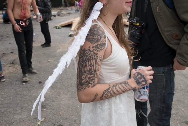 A woman with arm tattoos holds a beer during "Bike Kill 12" in the Brooklyn borough of New York City, October 31, 2015. (Photo by Stephanie Keith/Reuters)