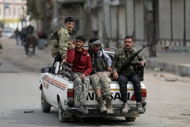 Turkish-backed Free Syrian army fighters ride on a back of a truck in Afrin, Syria March 19, 2018. (Photo by Khalil Ashawi/Reuters)
