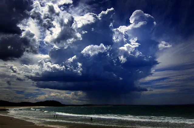 A giant storm cloud can be seen in the sky above swimmers near Mollymook Beach, south of Sydney, March 5, 2014. (Photo by David Gray/Reuters)