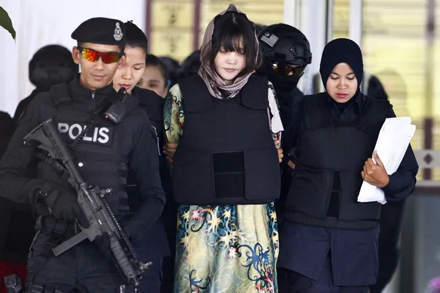 Vietnamese Doan Thi Huong, center, is escorted by police as she leaves after a court hearing at the Shah Alam High Court in Shah Alam, Malaysia, Thursday, April 5, 2018. Doan and Siti Aisyah of Indonesia have pleaded not guilty of killing Kim Jong Nam, the estranged brother of North Korean leader Kim Jong Un, on Feb. 13, 2017, at a crowded Kuala Lumpur airport terminal. (Photo by Sadiq Asyraf/AP Photo)