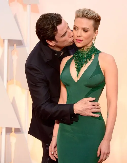John Travolta (L) kisses Scarlett Johansson as they arrive for the 87th annual Academy Awards ceremony at the Dolby Theatre in Hollywood, California, USA, 22 February 2015. The Oscars are presented for outstanding individual or collective efforts in 24 categories in filmmaking. (Photo by Mike Nelson/EPA)
