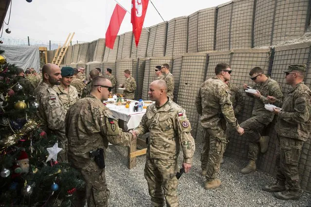 U.S. soldier from the 3rd Cavalry Regiment take part in a Christmas Eve celebration with soldiers from the Polish army's 21st Mountain Brigade on forward operating base Gamberi in the Laghman province of Afghanistan December 24, 2014. (Photo by Lucas Jackson/Reuters)