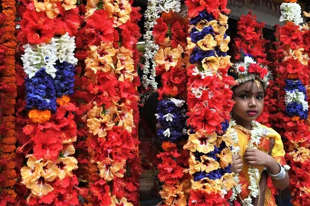 A girl looks on as she waits to participate in the “Kumari Puja” ritual, which is part of the annual Hindu festival of 'Ram Navami' at the Adyapeath ashram on the outskirts of Kolkata on March 30, 2023. (Photo by Dibyangshu Sarkar/AFP Photo)