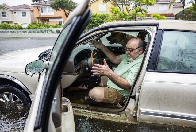 Mike Viesel and his dog Humi, wait in his flooded car for a tow truck after the car stalled on Taft Street due to heavy rain flooding the neighborhood on Wednesday, June 12, 2024, in Hollywood, Fla. The annual rainy season has arrived with a wallop in much of Florida, where a disorganized disturbance of tropical weather from the Gulf of Mexico has caused street flooding and triggered tornado watches but so far has not caused major damage or injuries. (Photo by Matias J. Ocner/Miami Herald via AP Photo)
