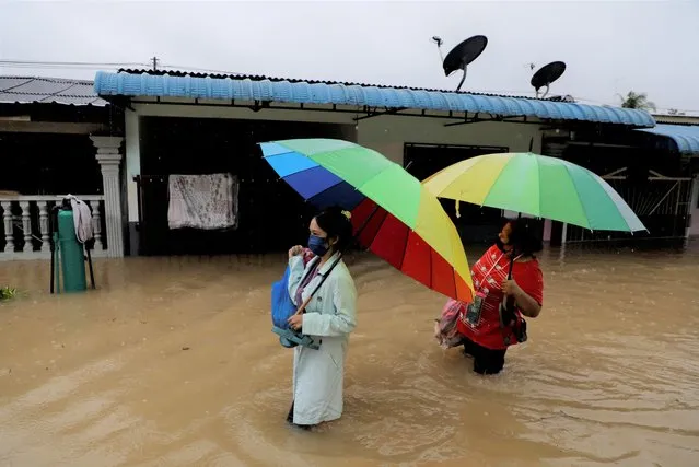 People wade through a flooded residential area at Yong Peng, Johor, Malaysia on March 4, 2023. (Photo by Hasnoor Hussain/Reuters)