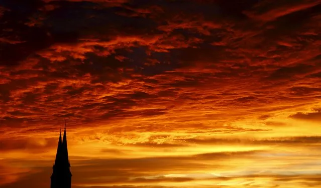 The rising sun illuminates the sky above the spires of a church in Vienna, Austria, November 17, 2015. (Photo by Heinz-Peter Bader/Reuters)