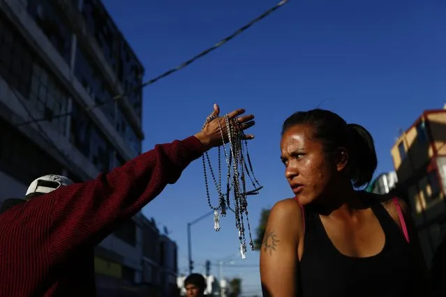 A man sells rosaries of La Santa Muerte (The Saint of Death), a cult figure often depicted as a skeletal grim reaper, near at the saint's altar at Tepito neighborhood, in Mexico City January 1, 2015. (Photo by Edgard Garrido/Reuters)