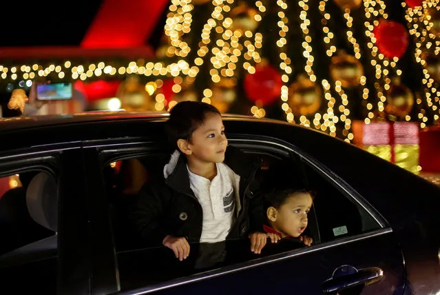 Children observe a person dressed as Santa Claus (not in the picture) from inside a vehicle in a drive-thru christmas village, amid the coronavirus disease (COVID-19) outbreak, in Ciudad Juarez, Mexico on December 3, 2020. (Photo by Jose Luis Gonzalez/Reuters)