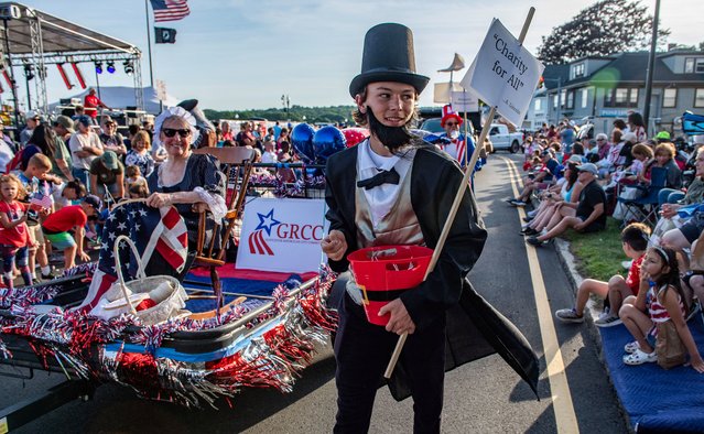 A person dressed as President Abraham Lincoln gives out candy as a woman dressed as Betsy Ross sits in a float and holds a US flag during the Fishtown Horribles Parade, ahead of Independence Day, in Gloucester, Massachusetts on July 3, 2024. The parade is part of the city’s July 4th celebrations. (Photo by Joseph Prezioso/AFP Photo)